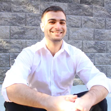 David smiling in front of gray brick