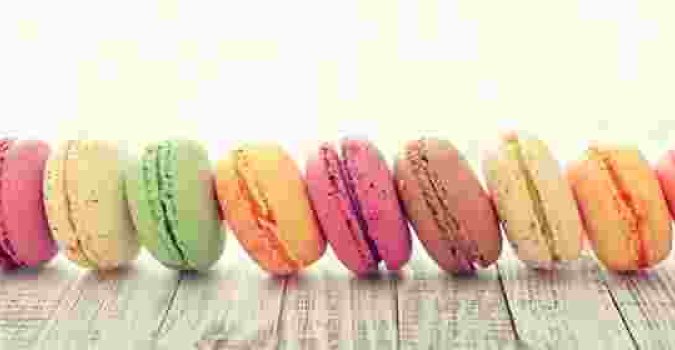 a horizontal row of colorful sandwich cookies shaped like hamburgers